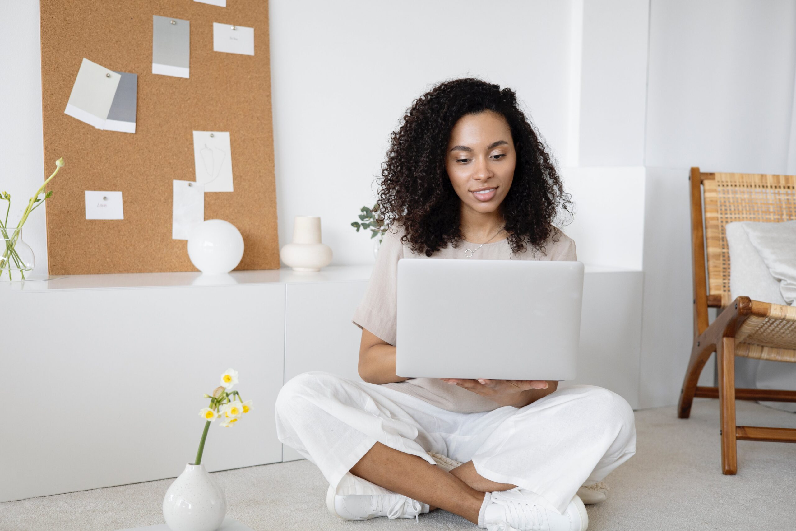 A woman in sitting on the floor using a laptop: outsourced digital marketing