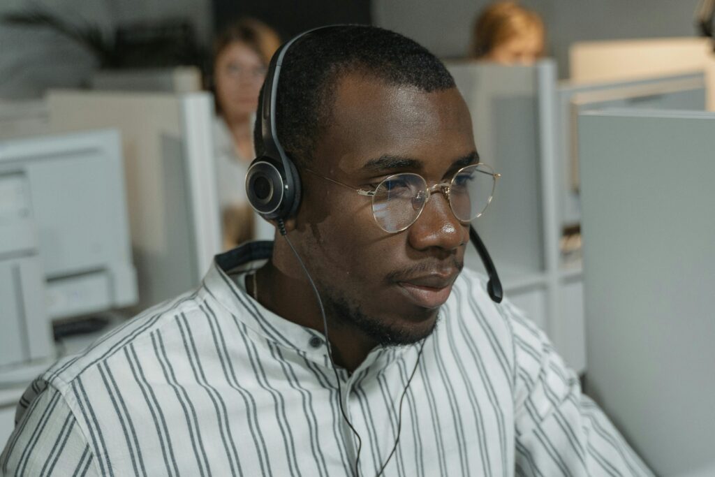 A man wearing a headset working at a call centre: outsourced customer service