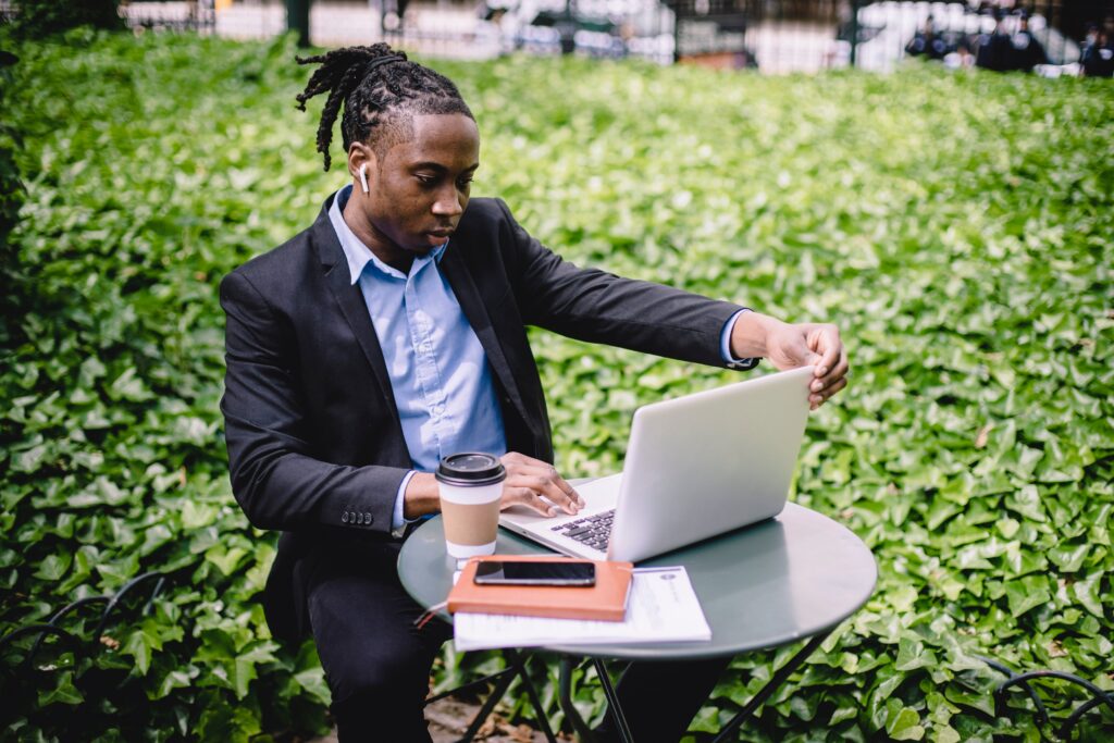A businessman using a laptop in a park: outsourced business development