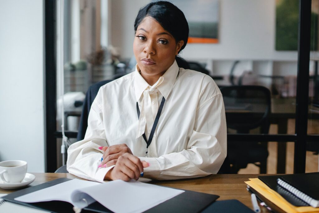 A black businesswoman sitting at a desk in an office: refund clerk