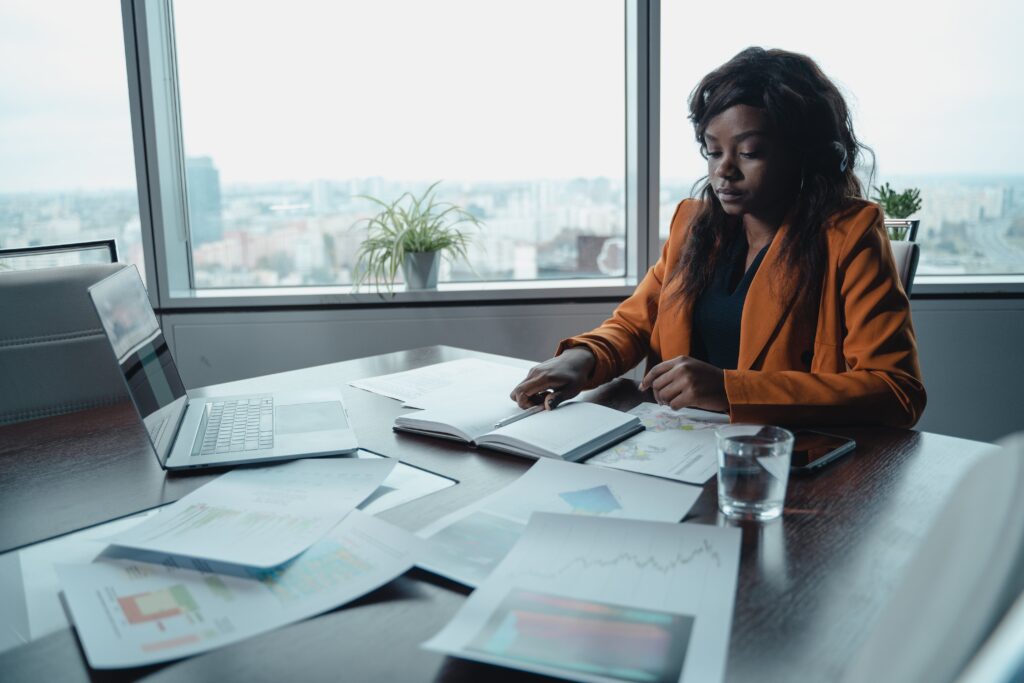 A woman sitting at a table working: outsourced business development